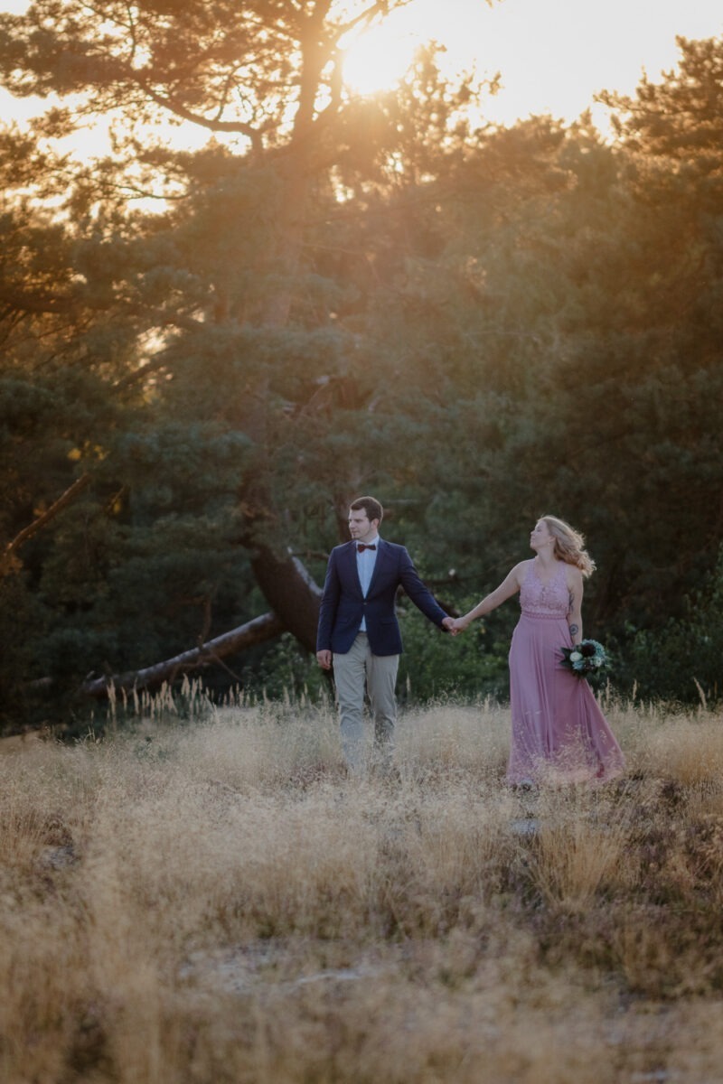 Paar in der Verdener Heide, auf die Kamera zulaufend, Sonnenuntergang