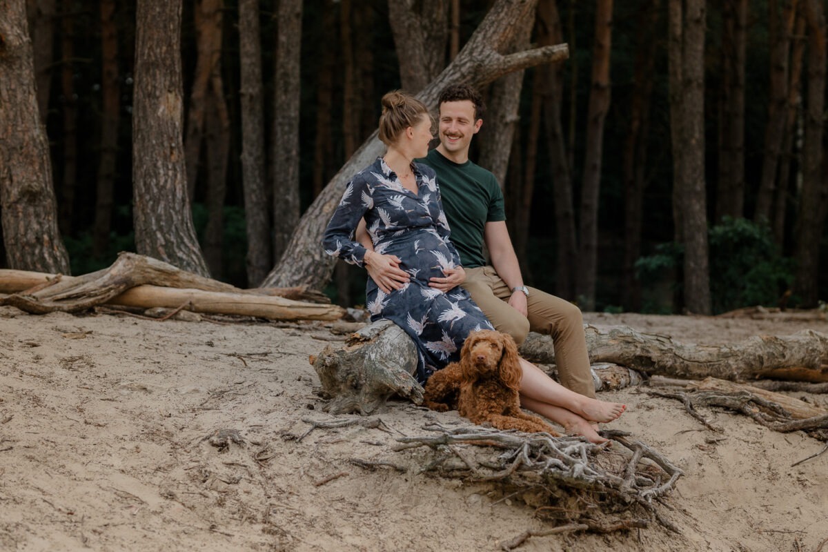 Ein Babybauchshooting mit Hund im Warwer Sand | Hannah, Max & Smutje 6 Paar in den Dünen mit Hund, Frau mit Babybauch, Wald im Hintergrund