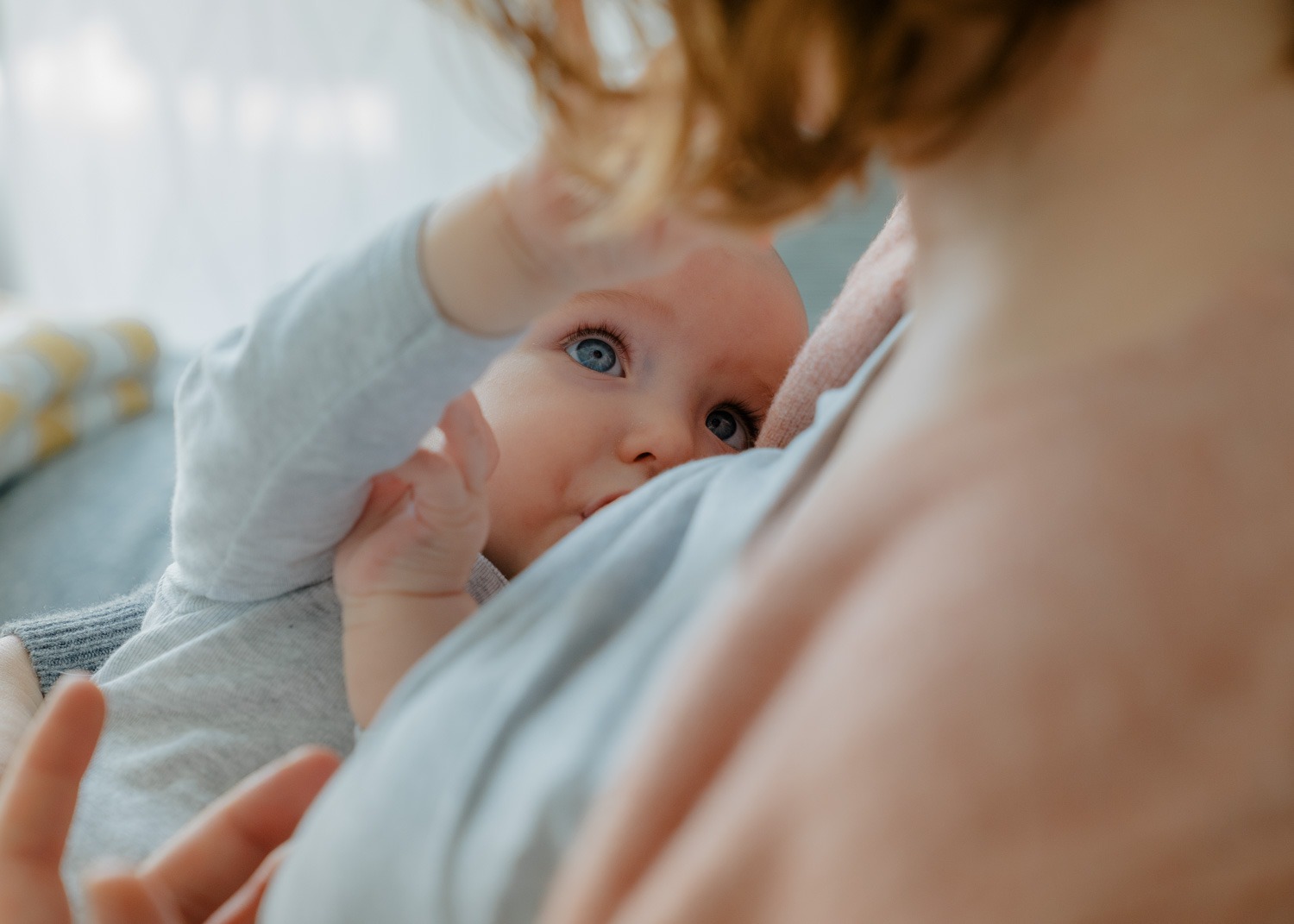 Stillfoto von Mutter mit Baby, Baby fasst Frau in die Haare
