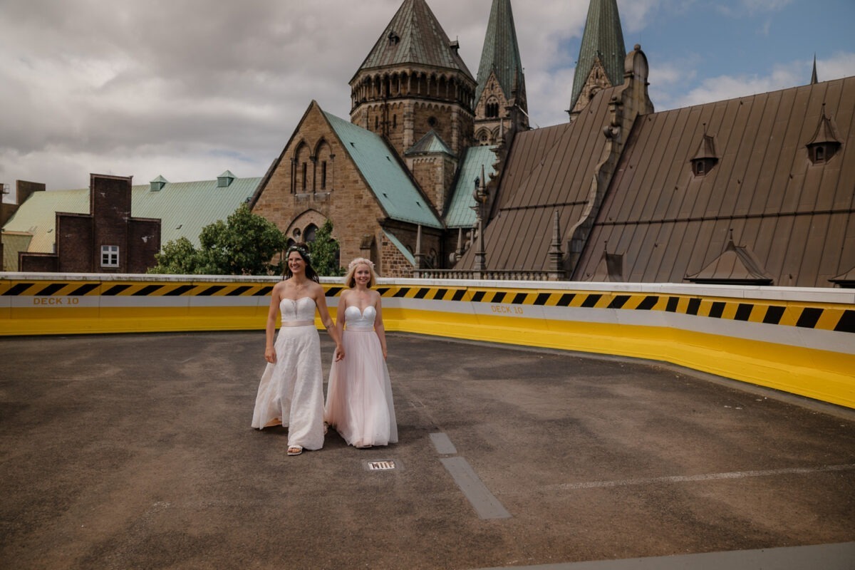 Brautpaarfotos auf Parkdeck in Bremen mit Bremer Dom im Hintergrund, zwei Bräute, gleichgeschlechtliche Hochzeit