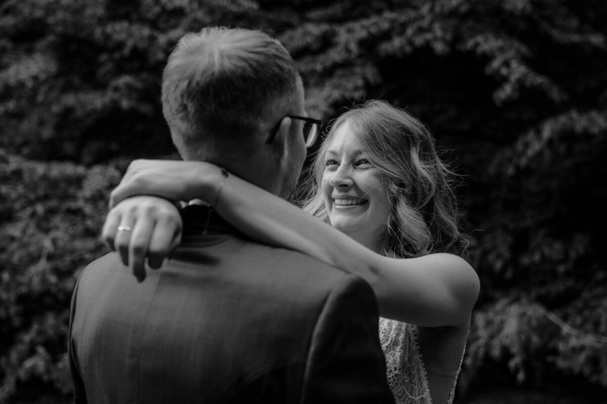Brautpaarshooting, Braut lachend und Mann umarmend