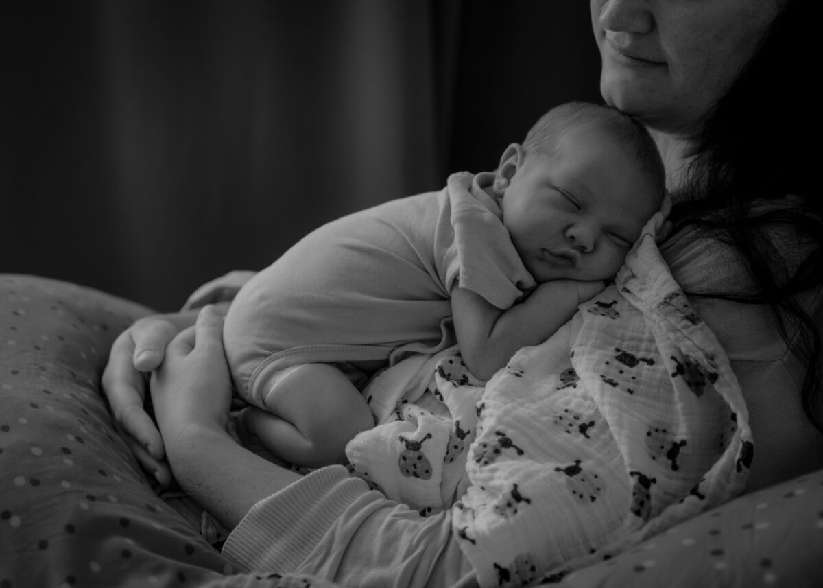 Schwarz-Weiss Aufnahme von neugeborenem Baby auf Mutter schlafend