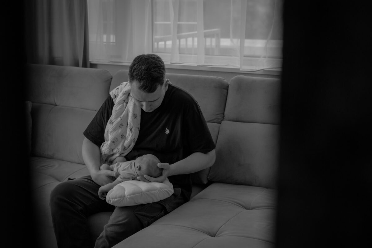 Schwarz-weiss Momentaufnahme von Vater mit neugeborenem Baby