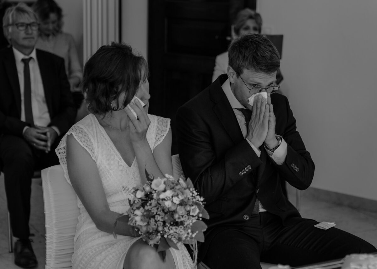 Schwarz-Weisse Aufnahme, Braut und Bräutigam mit Taschentuch während Trauung