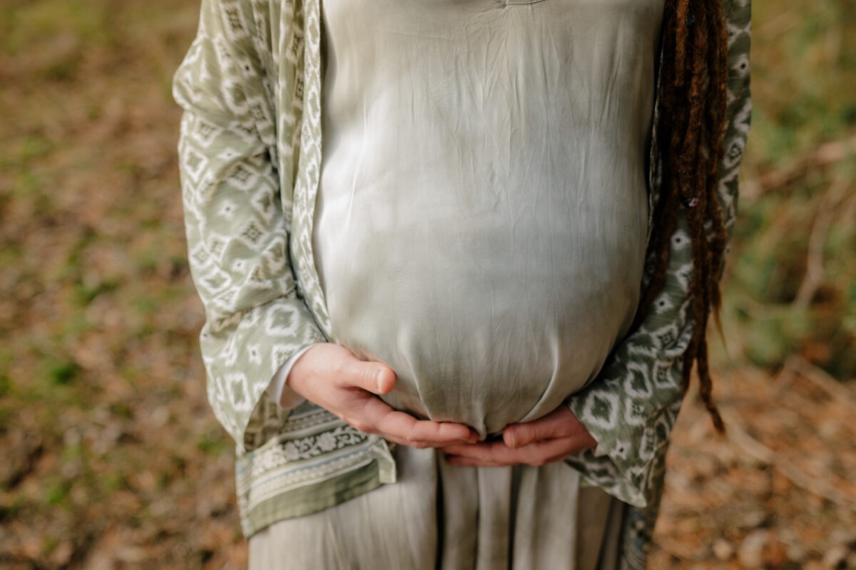Schwangerschaftsfotografin in Bremen: Unvergessliche Momente festhalten 9 Detailaufnahme Babybauch, frontal zur Kamera, Frau hält Bauch