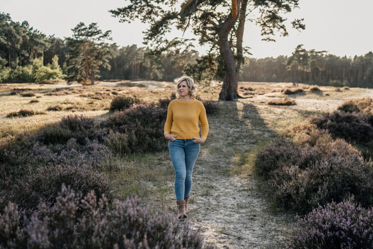 Hochzeitsfotografin Worpswede 8 Ines läuft über einen Sandweg durch Heide und Kiefern